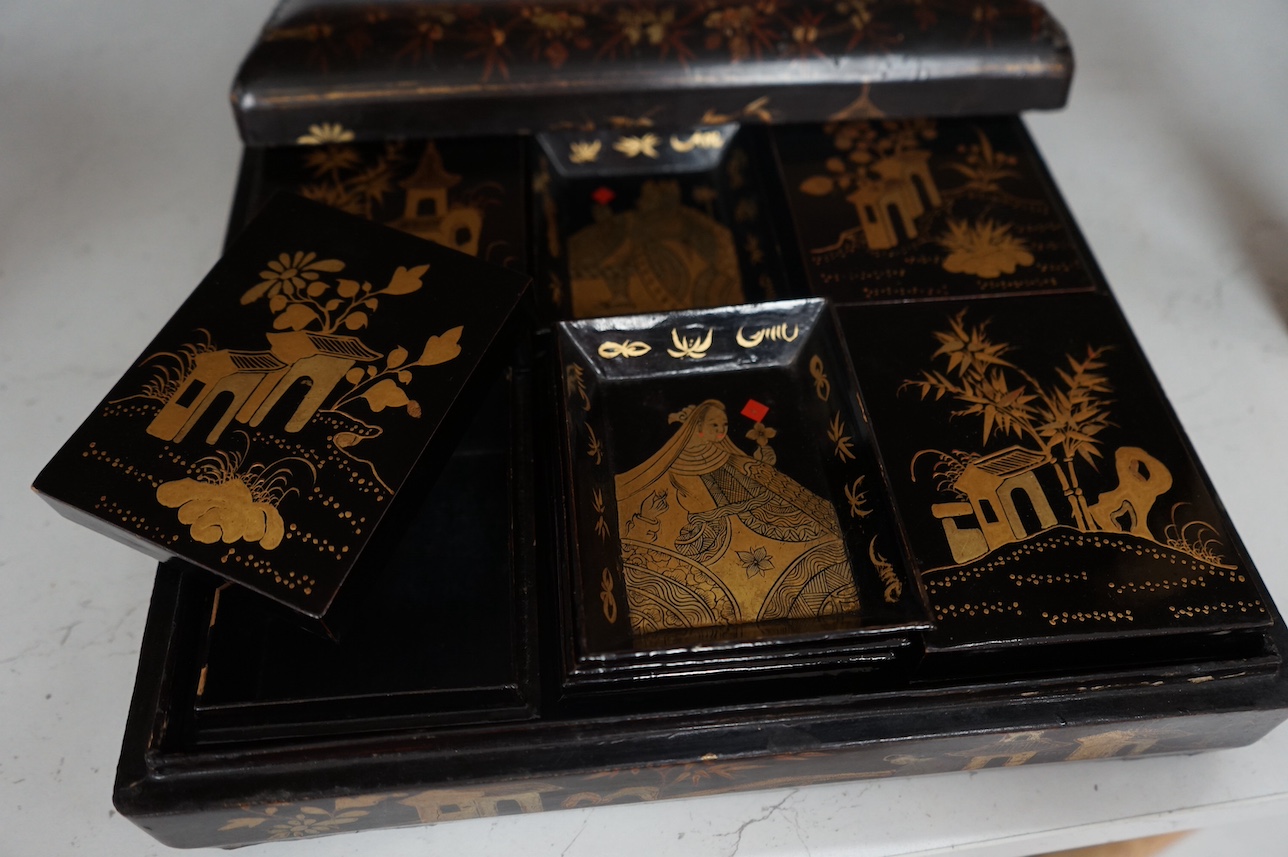 A mid 19th century Chinese gilt decorated black lacquer games box, 31cm wide. Condition - fair to good